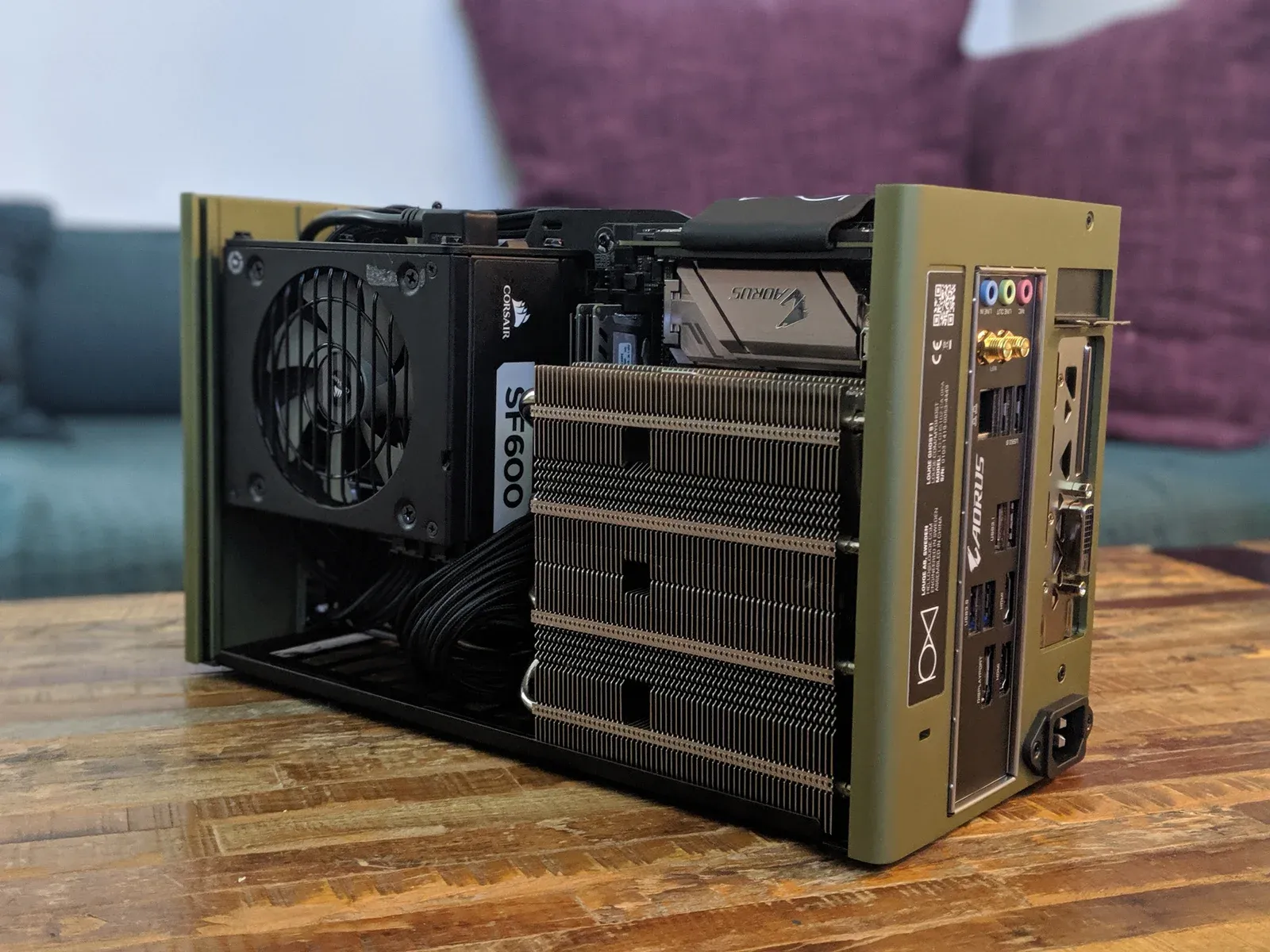 My compact ITX computer with its side panel removed, showing tightly fitted components inside an olive-green case.
